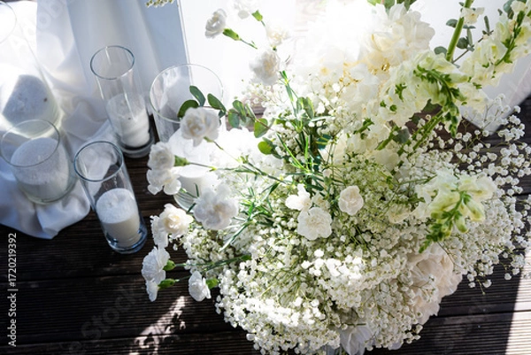 Fototapeta White floral bouquet with roses and daisies arranged in elegant vase for wedding table decoration, natural fresh flowers as romantic festive centerpiece for ceremony, celebration and reception event