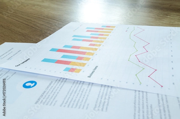 Obraz Workplace on wooden table with graph papers