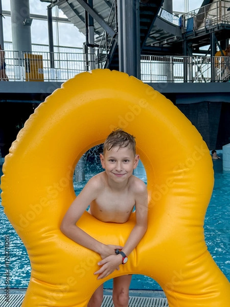 Obraz Teen boy with giant inflatable float in indoor water park