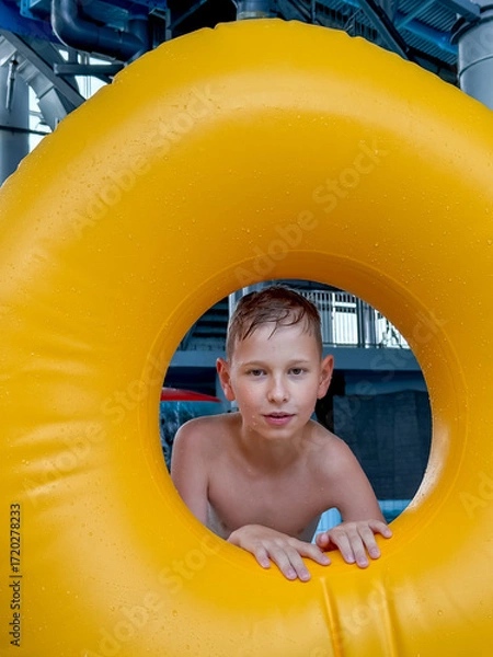 Obraz Teen boy with giant inflatable float in indoor water park