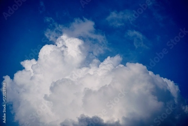 Obraz Towering cumulus cloud against deep blue sky