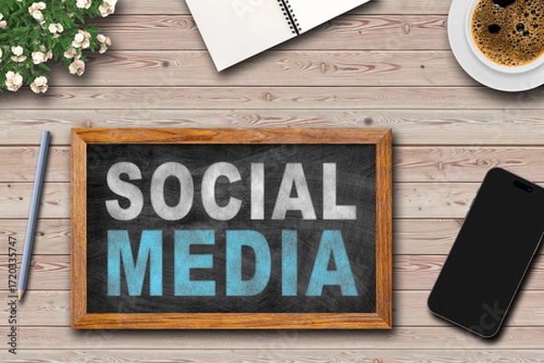 Fototapeta Social media written on framed Blackboard with  cup of coffee, notepad and pen on wooden table background