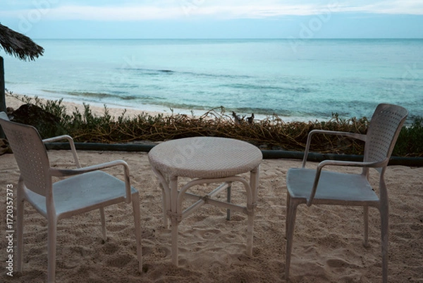 Fototapeta Inviting beach setup with tables and chairs create a relaxed atmosphere.