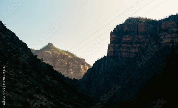Fototapeta Charming mountain peaks partially illuminated by soft light in the morning.