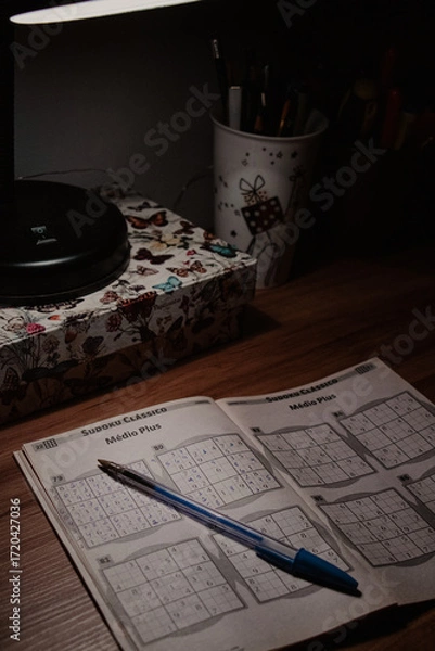 Fototapeta Open Sudoku with Pen on Desk at Night