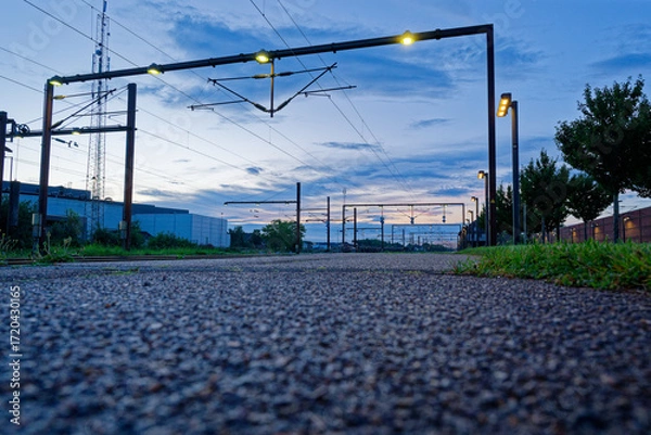 Fototapeta Catenary frame on twin poles with yellow lamps and wires in Padborg, Denmark