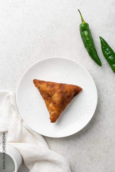 Fototapeta Overhead view of samosa on a white plate, top view of beef samosa on a white background