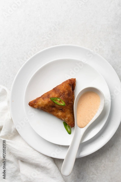 Fototapeta Overhead view of samosa on a white plate, top view of beef samosa on a white background