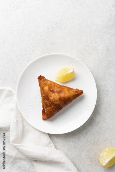 Fototapeta Overhead view of samosa on a white plate, top view of beef samosa on a white background