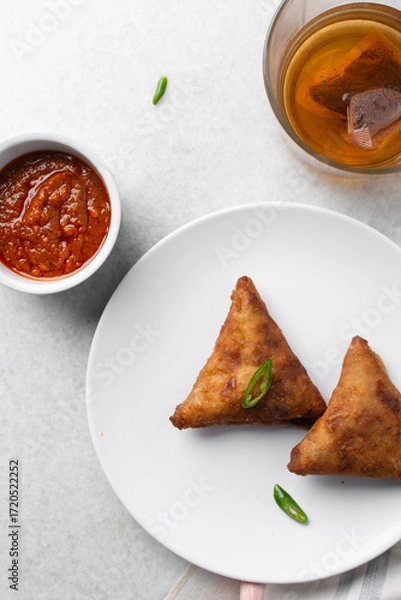Fototapeta Overhead view of samosa on a white plate, top view of beef samosa on a white background