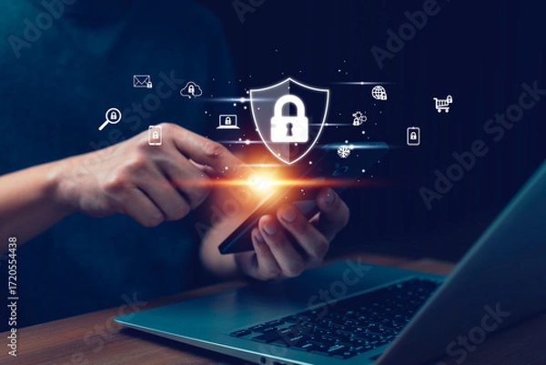 Fototapeta Man using smartphone and laptop with glowing security lock shield icon, representing cybersecurity, data protection, privacy, mobile security, online safety, secure connection and digital protection.