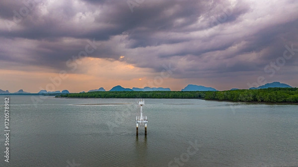 Fototapeta Built beside the mangrove-lined shores, the lighthouse overlooks a narrow but deep tidal channel that leads from a coastal Bang Phat fishing village at Phang Nga to the vast sea beyond.