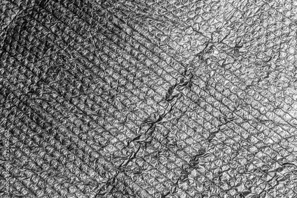 Fototapeta Crumpled silver foil texture with intricate patterns and reflective surface