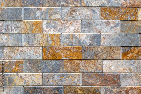 Fototapeta Colorful textured stone brick wall with varied patterns and tones