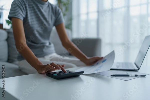 Fototapeta Asian women using calculator calculating Monthly expenses
And Working With Laptop at home