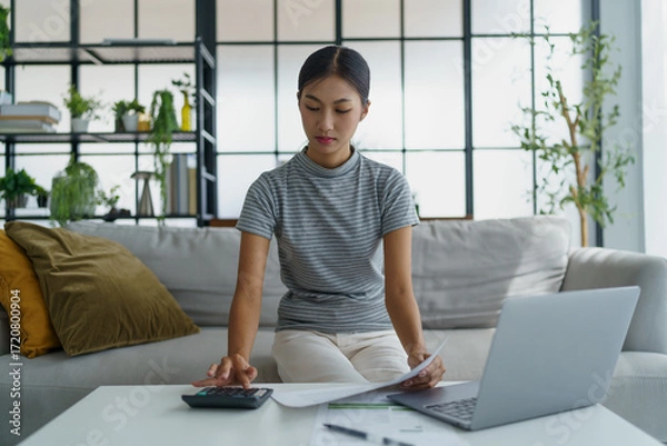 Fototapeta Asian women using calculator calculating Monthly expenses
And Working With Laptop at home