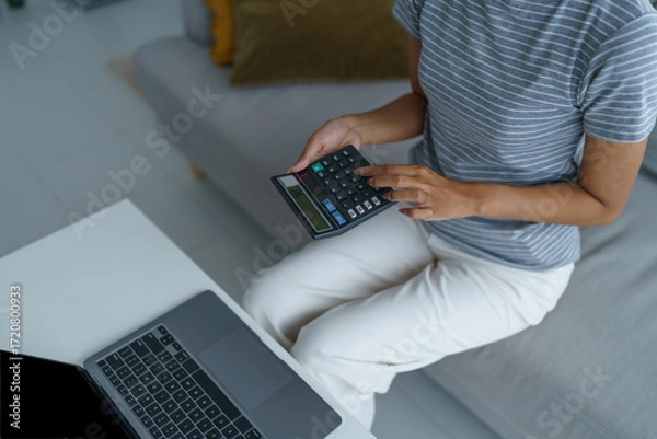 Fototapeta Asian women using calculator calculating Monthly expenses
And Working With Laptop at home