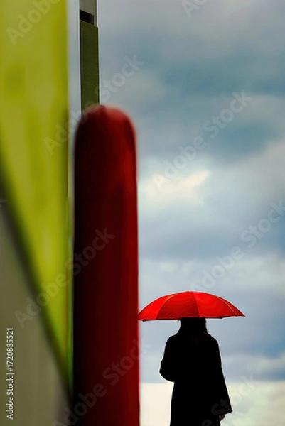Fototapeta 雲の流れを眺める赤い傘の女性