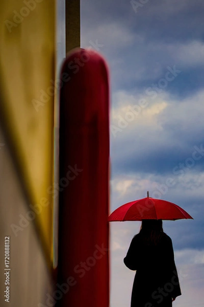 Fototapeta 曇り空を眺める赤い傘の女性