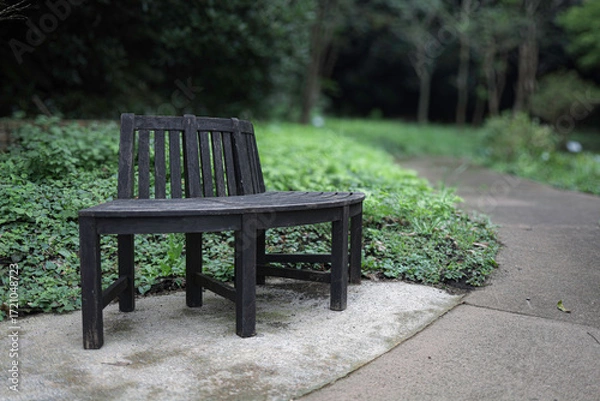 Fototapeta 緑のぼけた背景、濃い茶色の円形のベンチ