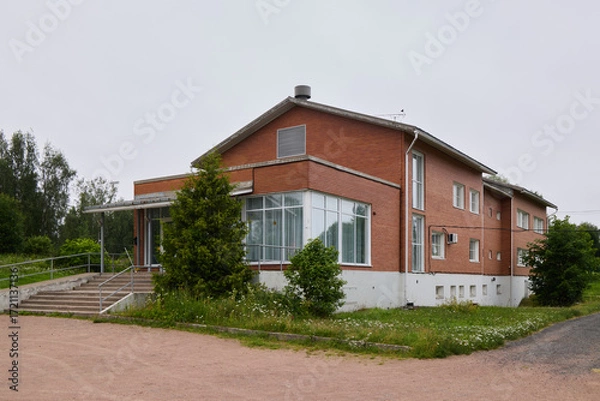 Fototapeta A Modern Brick Building That is Beautifully Surrounded by Lush Greenery and Nature