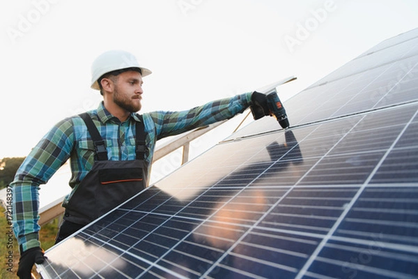 Fototapeta Technician installing solar panels for renewable energy production