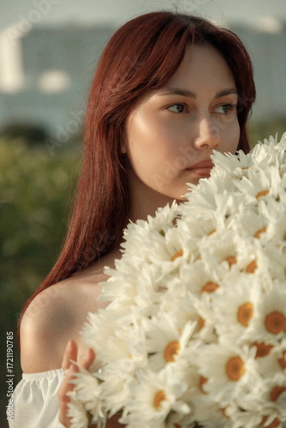 Fototapeta a bouquet of white daisies in close-up in the hands of a girl. film and grain effect