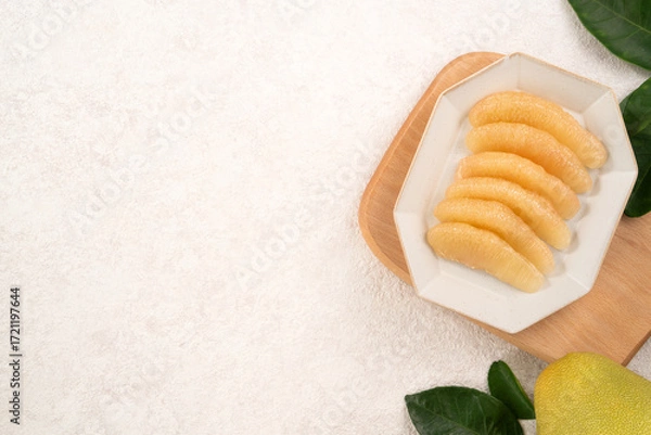 Obraz Fresh pomelo fruit with leaf on white table background.