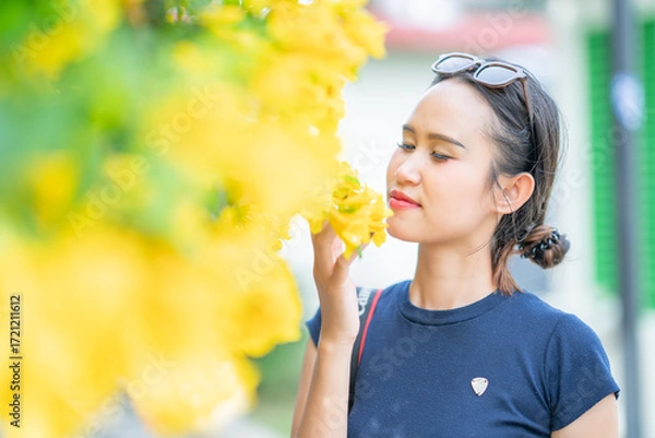 Fototapeta 나무와 노란 꽃을 배경으로 태국의 미녀 모델이 웃으면서 포즈를 취한 사진,
