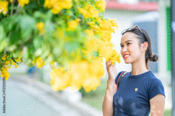 Fototapeta 나무와 노란 꽃을 배경으로 태국의 미녀 모델이 웃으면서 포즈를 취한 사진,
