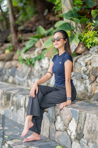 Fototapeta 나무와 노란 꽃을 배경으로 태국의 미녀 모델이 웃으면서 포즈를 취한 사진,
