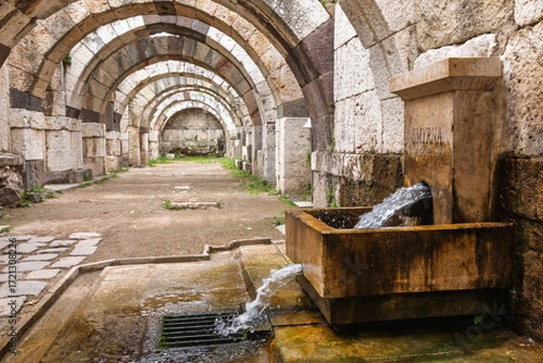 Fototapeta Ancient Roman walkway featuring restored water fountain at Smyrna Agora archaeological site in Izmir Turkey