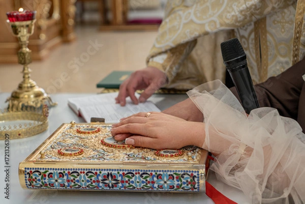 Fototapeta Close-up of the hands of the bride and groom praying in the church