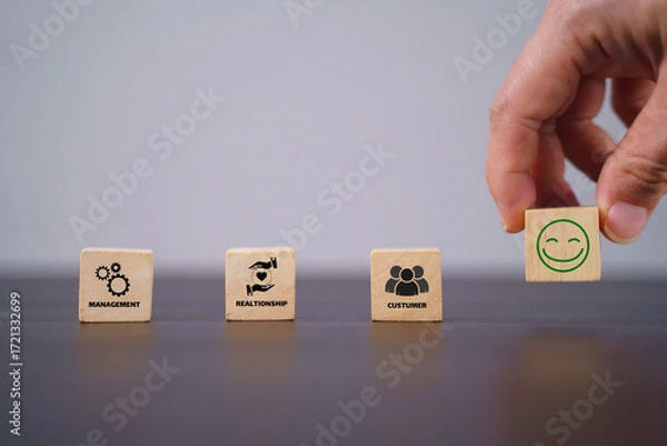 Fototapeta CRM, Customer relationship management concept. Customer satisfaction, retention strategies. CRM or customer loyalty program banner. Wooden cube blocks with CRM symbols on minimal background.