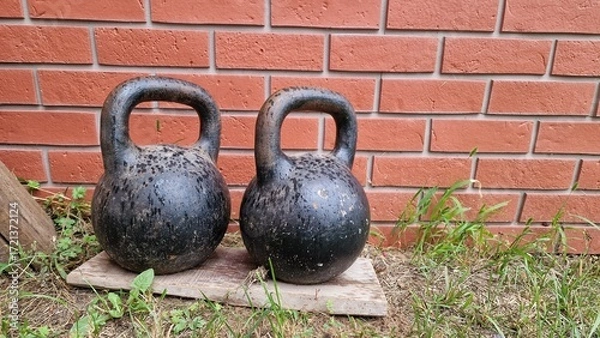 Obraz Two weights near a brick wall