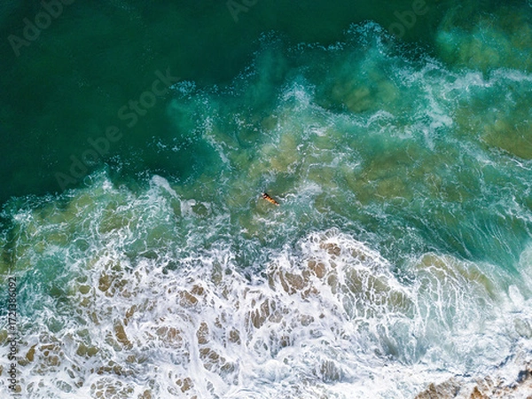 Fototapeta Aerial View of surfer floats on a board in Nazare, Portugal