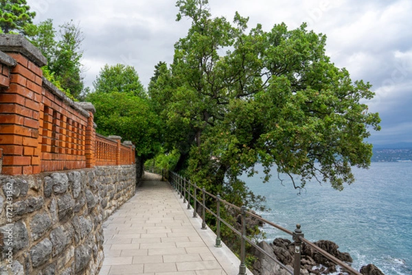 Fototapeta Stone seaside path Lungomare with railing along Adriatic coast in Opatija, Croatia