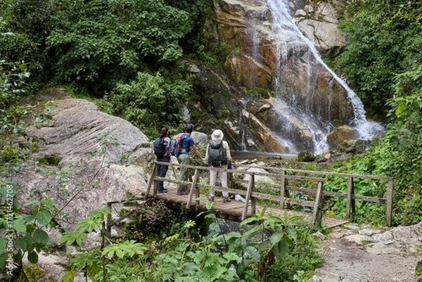 Fototapeta A group of tourists pause in awe along the Inca Trail. United by discovery, they share a moment of amazement on this legendary journey toward Machu Picchu.