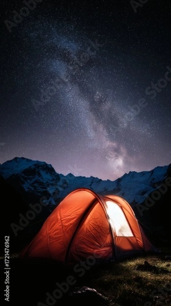 Fototapeta starlight. A cozy tent under a starry Milky Way sky creates a magical nightscape in the mountains. travel magazines, destination branding, designed for outdoor magazines and nature guides.