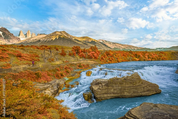 Fototapeta Beautiful waterfall with turquoise river and autumn foliage in Torres del Paine, Patagonia, Chile, under bright sky and mountain backdrop.