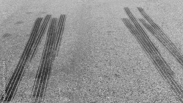 Fototapeta Black tire marks on road, Black rubber tire marks and tread marks, Tire trace track wheels texture and background, Auto tire tread grunge, Car wheel tyre tread track black tyre print.