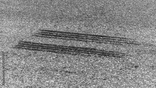 Fototapeta Black tire marks on road, Black rubber tire marks and tread marks, Tire trace track wheels texture and background, Auto tire tread grunge, Car wheel tyre tread track black tyre print.