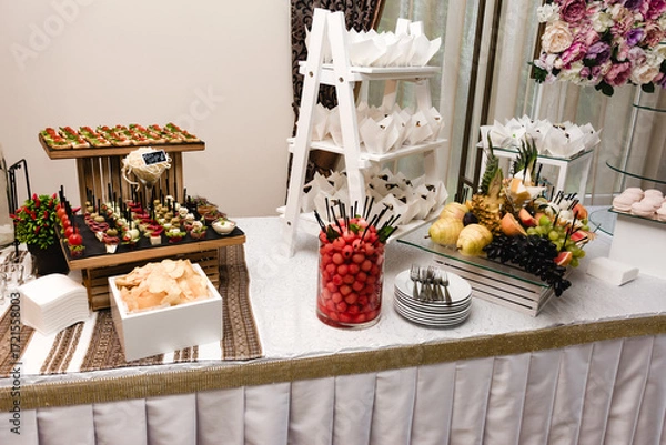 Fototapeta Elegant buffet table with appetizers, desserts, and fruit displays. Perfect for a wedding or special event.