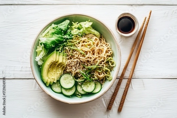 Fototapeta Cold ramen salad bowl with cucumbers, lettuce, avocado slices, and sesame dressing in pastel bowl