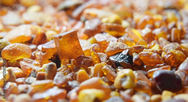 Fototapeta Amber stone  rough unpolished closed up background. Natural condition against a light.