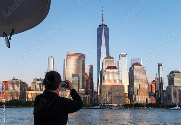 Fototapeta Tourist taking a photo of Manhattan from a boat. 
