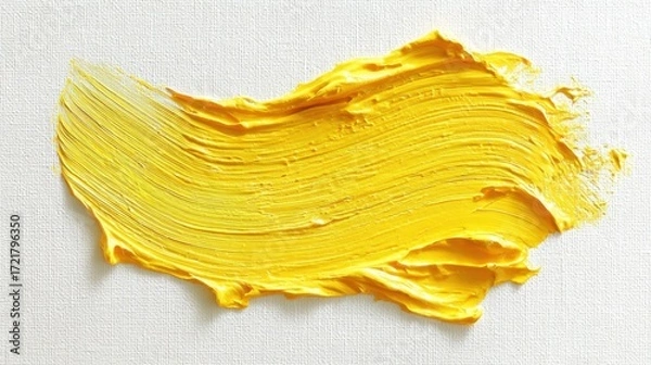 Fototapeta The vibrant yellow paint stroke on a textured canvas background.