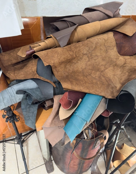 Fototapeta Leather scraps gathered in a workshop in the afternoon light