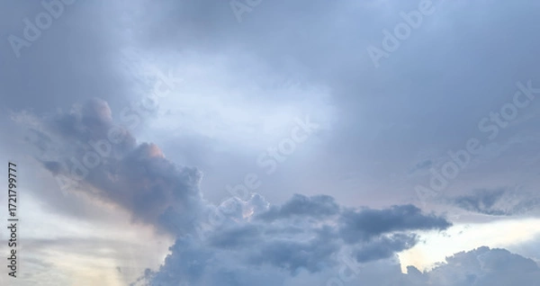 Fototapeta Clouds gather in the evening sky over a serene landscape