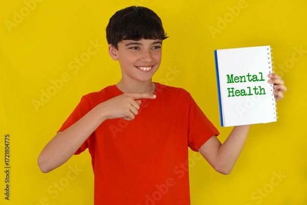 Fototapeta mental health concept. portrait of a smiling teenager with freckles, pointing to a notebook